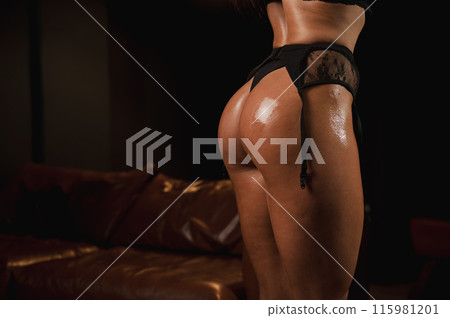 Close-up of a woman's tanned athletic buttocks oiled up. Close-up of a woman's tanned athletic buttocks oiled up. 115981201