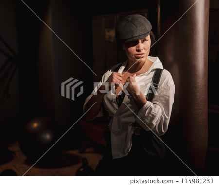 Caucasian woman in a men's suit in the style of Peaky Blinders. Caucasian woman in a men's suit in the style of Peaky Blinders. 115981231