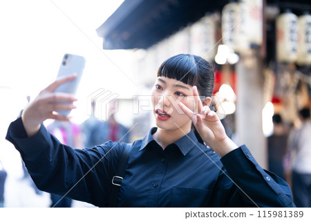 Young woman taking a selfie at a tourist spot Young woman taking a selfie at a tourist spot 115981389