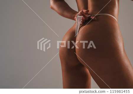 Close-up of female buttocks in drops of water. Close-up of female buttocks in drops of water. 115981455