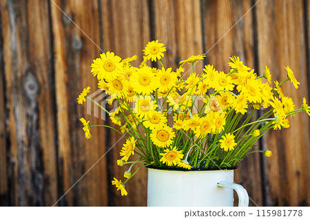 Yellow daisy flowers bouquet. Rustic background. 115981778