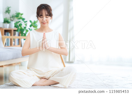 一個女人在客廳做瑜伽 115985453