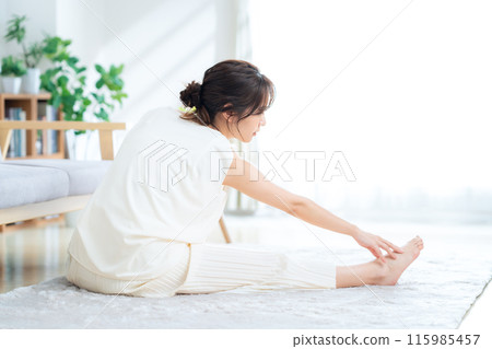 Woman doing yoga in the living room Woman doing yoga in the living room 115985457
