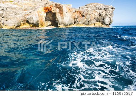 The ocean and hard-looking rocks seen from a sightseeing boat 115985597