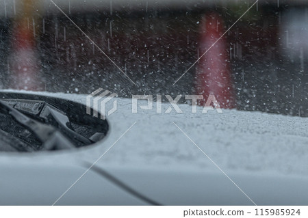 大雨打在一輛白色汽車的引擎蓋上 115985924