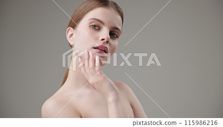 Beauty, health, cosmetics, anti-aging therapy and skin care concept - young beautiful brunette Caucasian woman posing and looking at the camera with a calm confident look like in a mirror 115986216