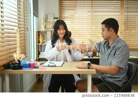 Physiotherapist examining male patient with frozen shoulder or joint stiffness in the clinic 115986636