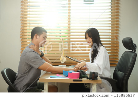 Physiotherapist examining male patient with frozen shoulder or joint stiffness in the clinic 115986637