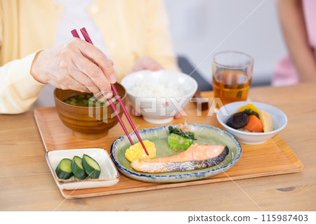 用餐場景:一位高級婦女的手正在享用餐點 用餐場景:一位高級婦女的手正在享用餐點 115987403