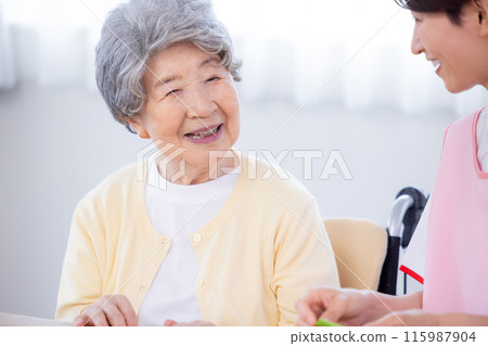 Nursing image Senior woman and caregiver folding origami Nursing image Senior woman and caregiver folding origami 115987904