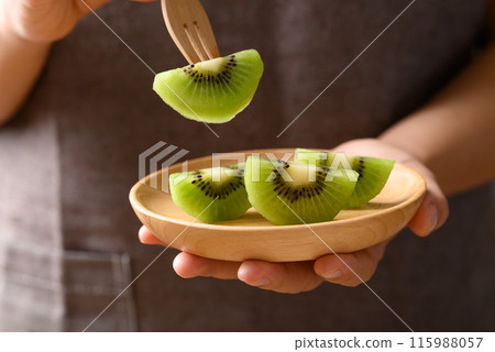Sliced green kiwi fruit on wooden plate ready to eating, Healthy fruit Sliced green kiwi fruit on wooden plate ready to eating, Healthy fruit 115988057