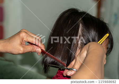 Apprentice hairdresser straightening woman long hair, hairdressing hairstyle styling, beauty salon parlour parlor, formal occasion graduation wedding engagement prom upstyle Apprentice hairdresser straightening woman long hair, hairdressing hairstyle styling, beauty salon parlour parlor, formal occasion graduation wedding engagement prom upstyle 115988692