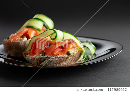Sandwiches with smoked trout, cream cheese, fresh cucumber, and capers. Sandwiches with smoked trout, cream cheese, fresh cucumber, and capers. 115989012