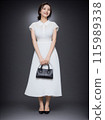 一件白色禮服的美麗的少婦拿著袋子 115989338