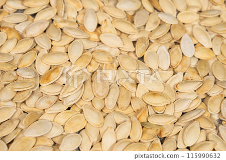 Close-up of unpeeled pumpkin seeds from above. 115990632