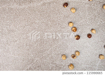 Roasted hazelnuts on a gray stone background top view, place for text 115990665