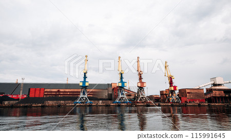 A large industrial area with a lot of cranes and a large body of water A large industrial area with a lot of cranes and a large body of water 115991645