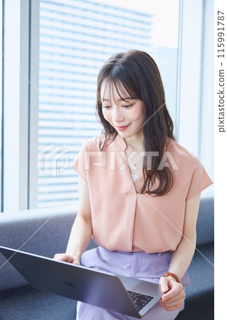 在辦公室沙發上看電腦的女人 在辦公室沙發上看電腦的女人 115991787