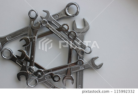 Triangular structure of iron wrenches of different types and diameters isolated on white  115992332