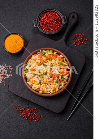 Delicious boiled rice with vegetables corn, carrots, peas with salt 115992828