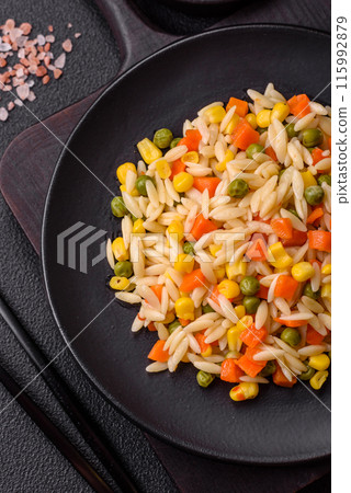 Delicious boiled rice with vegetables corn, carrots, peas with salt 115992879