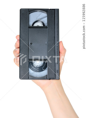 Woman hand holds a retro old analog video cassette, isolated on white background, retro things Woman hand holds a retro old analog video cassette, isolated on white background, retro things 115992886