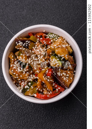 Spicy Asian dish with sliced meat fillet, hot pepper, carrots and sesame seeds 115992902