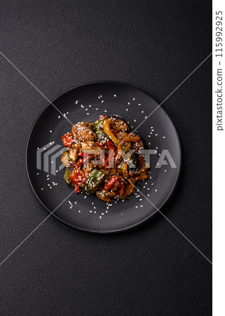 Spicy Asian dish with sliced meat fillet, hot pepper, carrots and sesame seeds 115992925