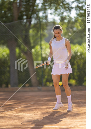 A woman is playing tennis on a court A woman is playing tennis on a court 115993488