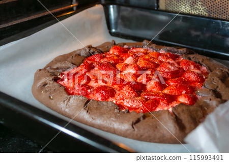 The process of baking a galette with strawberries in the oven. The process of baking a galette with strawberries in the oven. 115993491