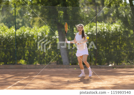 A woman is playing tennis on a court A woman is playing tennis on a court 115993540