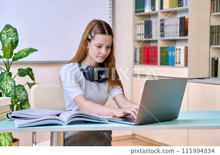 Teenage girl student studying in high school library 115994834