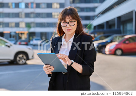 Mature woman manager agent using digital tablet for work, city background Mature woman manager agent using digital tablet for work, city background 115994862