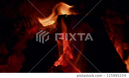 Natural wood log fire embers glowing great for background. Slow motion burning bonfire. Close up. 115995254