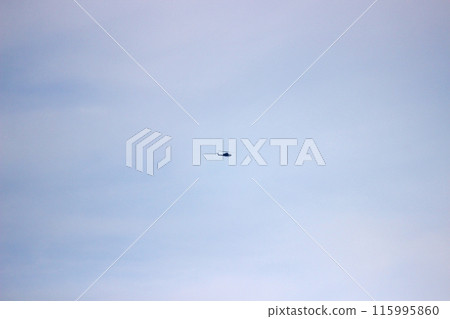 Photograph a helicopter flying in the distant sky 115995860