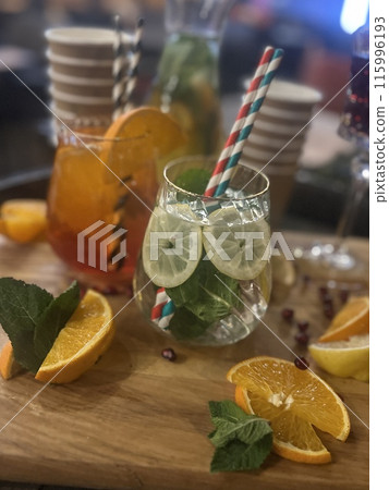 Refreshing summer cocktail with orange, lemon and mint on wooden background Refreshing summer cocktail with orange, lemon and mint on wooden background 115996193