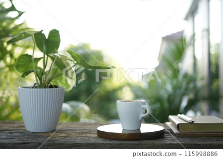 small white cup on wooden tray and notebook and plant pot balcony outdoor chilling 115998886