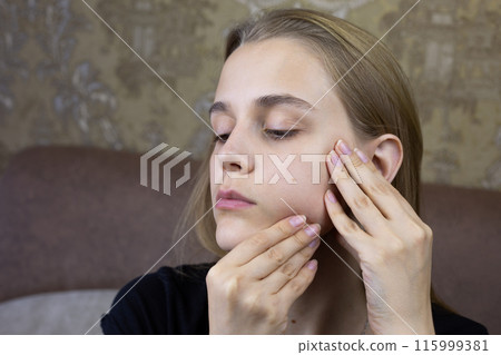 European young girl makes facial massage with her hands to herself, special skin care product for the girl face 115999381