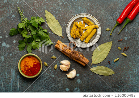 Various Indian spices and herbs arranged on a rustic background . 116000492