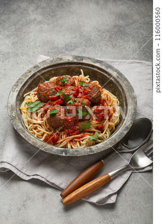 Spaghetti being served with meatballs and tomato sauce in rustic bowl, Italian cuisine 116000560