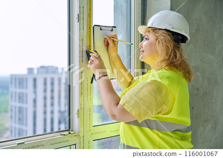 Female window decorator designer measuring window with tape measure Female window decorator designer measuring window with tape measure 116001067