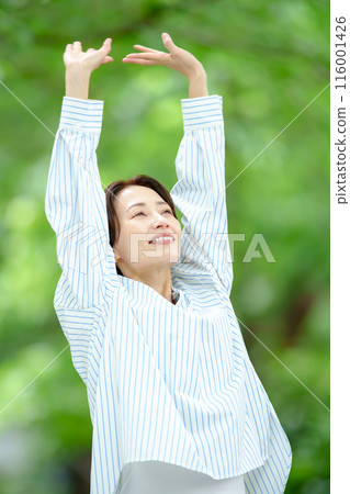 A woman stretching in fresh green A woman stretching in fresh green 116001426