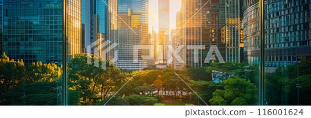 Morning sunlight over cityscape with lush greenery and tall buildings. Perfect for business themes and sustainable urban development. 116001624