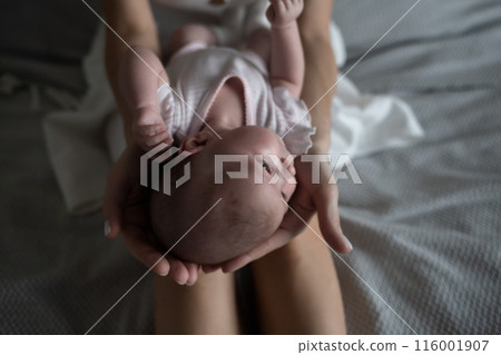 little cute baby girl lies in her mother's arms 116001907