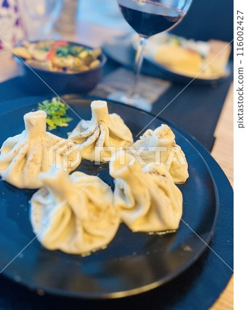Georgian dumplings khinkali on a plate with red wine Georgian dumplings khinkali on a plate with red wine 116002427