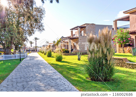 Modern buildings on the island of Crete, Greece. Hotel area and palm trees. Luxury tropical apartment resort complex. 116002686