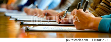 Group of people taking notes during a business meeting. Symbolizes corporate teamwork and collaboration. 116003425