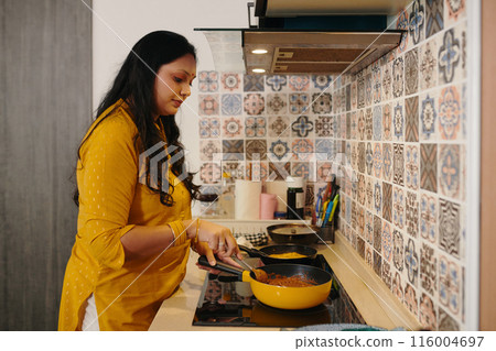 Woman Cooking Dinner For Her Family 116004697