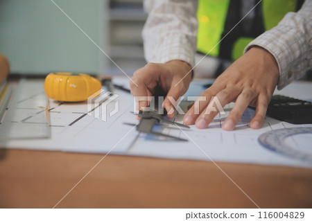 engineer people meeting working and pointing at a blueprint in office for discussing. Engineering tools and construction concept engineer people meeting working and pointing at a blueprint in office for discussing. Engineering tools and construction concept 116004829