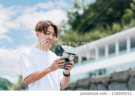 A video creator filming outdoors using a drone A video creator filming outdoors using a drone 116005011